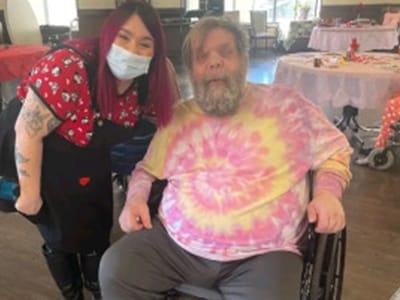 Staff member posing with resident in a common area