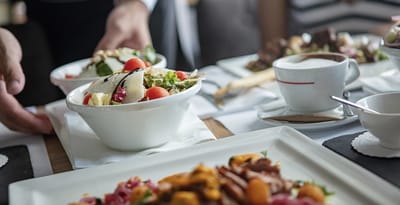 Service of fresh salads and meals at a dining setting