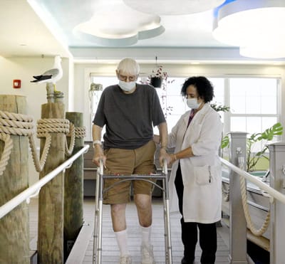 Staff assisting a resident in an interior corridor