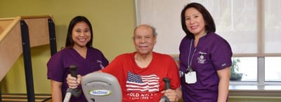 Senior resident exercising with staff support