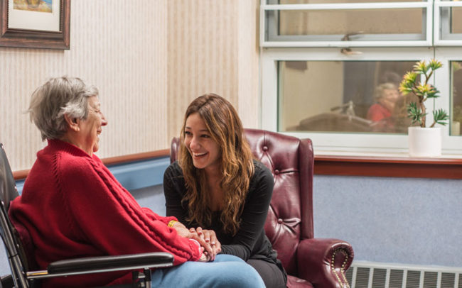Two women laughing in a cozy lounge area