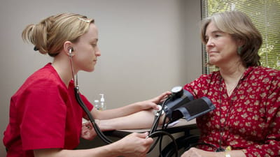 Nurse taking blood pressure of a resident