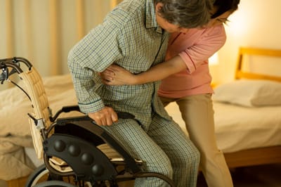 Caregiver assisting a resident in a bedroom