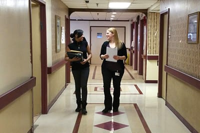 Staff members walking in a well-lit facility hallway
