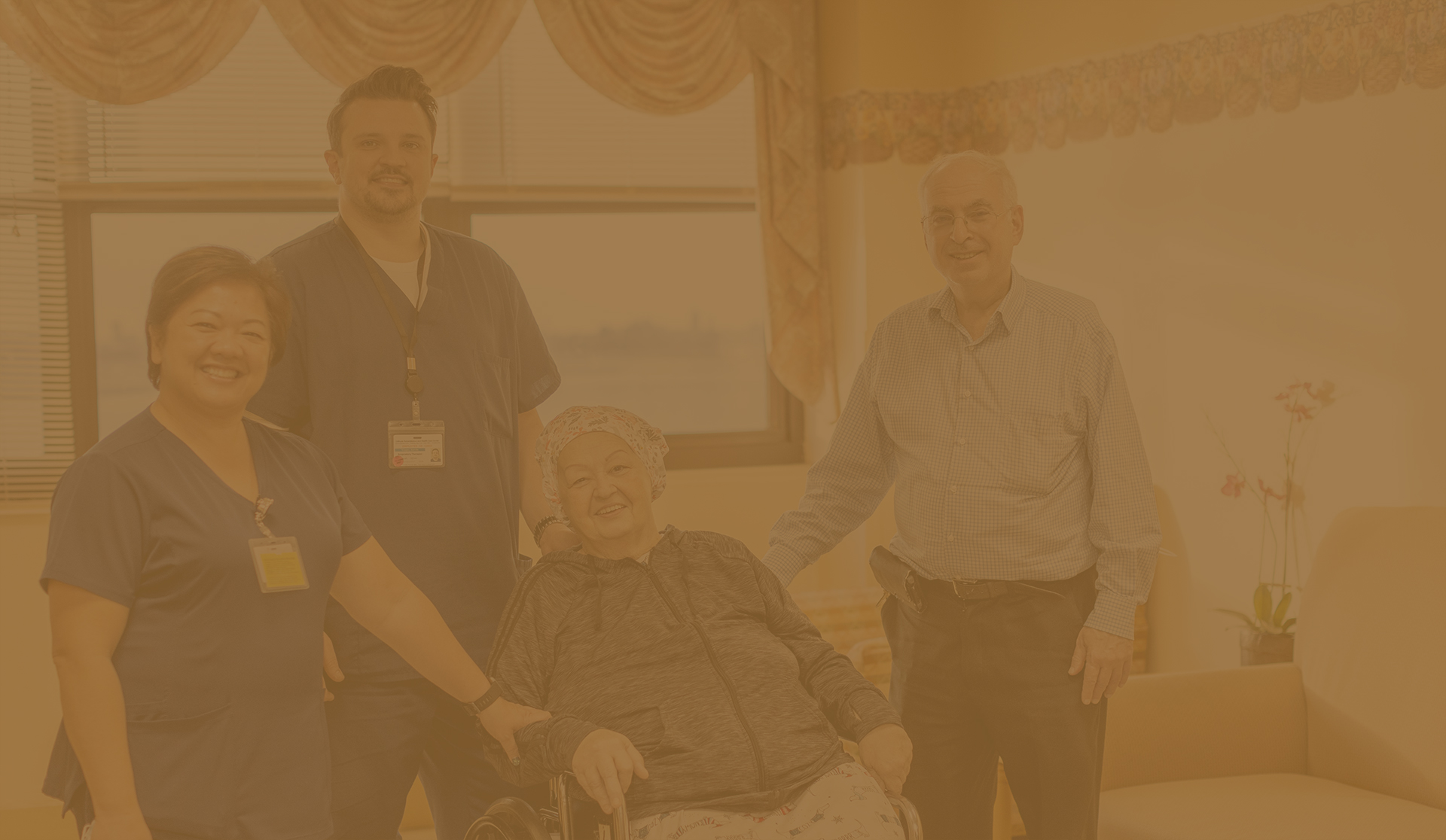 Staff and resident smiling together in a facility room