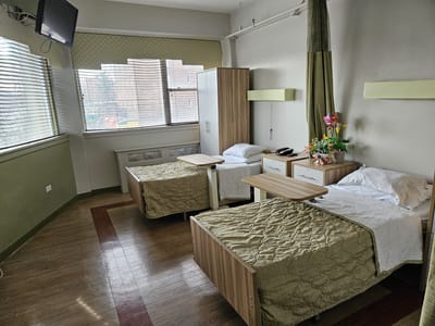 A bright resident room with two beds and decor