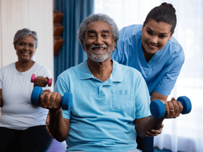 Residents exercising with weights in an activity room