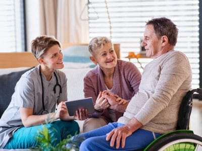 Caregiver interacting with happy residents in a cozy room