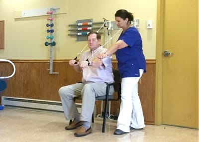 Physical therapy session with a resident and staff member