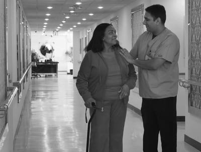 Care staff assisting a resident in a hallway