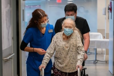 Care staff assisting a resident in a hallway