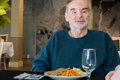Resident enjoying a meal in the dining room
