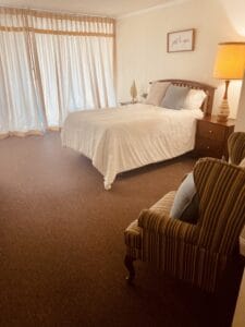 Shaker Gardens Assisted Living, Nursing Home in Shaker Heights, OH — Well-furnished bedroom with large windows and soft lighting