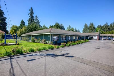 Exterior view of the senior living facility with landscaped area