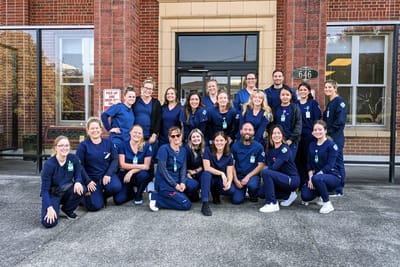 Group of staff members posing at the facility entrance