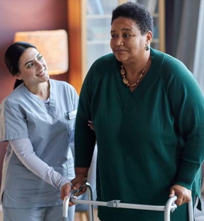 A caregiver assisting a resident with a walker