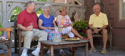 Four residents enjoying drinks on a patio