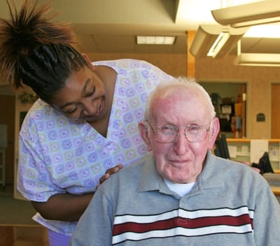 Staff member assisting a resident in a care facility
