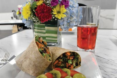 Healthy meal featuring a wrap, fruits, and a drink