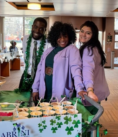 Staff serving snacks at an indoor community event
