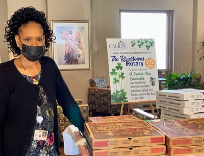 Staff member with pizza boxes in a community space