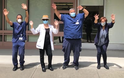 Staff members celebrating outdoors with hands raised
