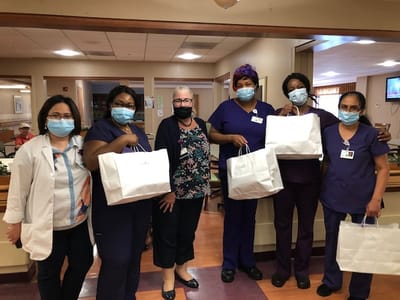 Staff members posing with gift bags in a common area