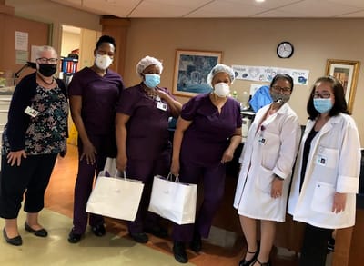 Staff members celebrating with gift bags in a facility lobby