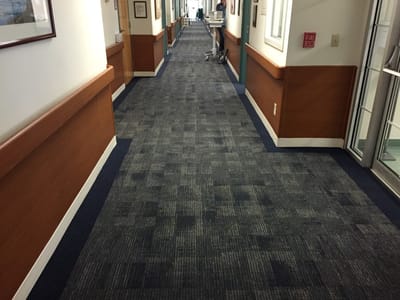 A hallway in a senior living facility with carpet flooring