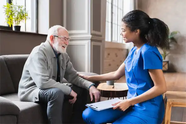 Staff member engaging with a resident in a cozy interior