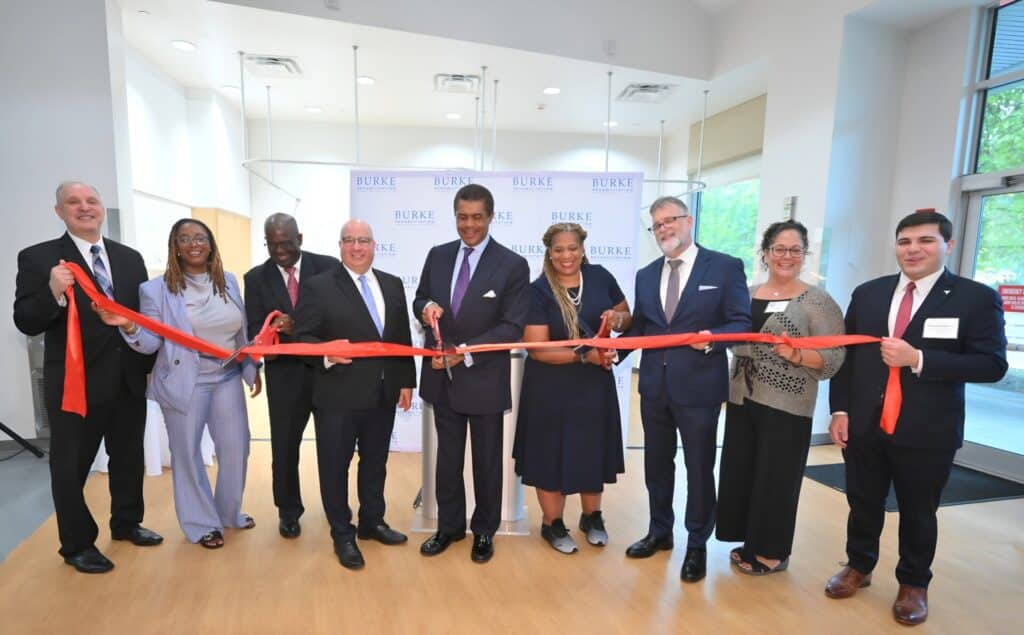 People cutting a ribbon at a facility opening event