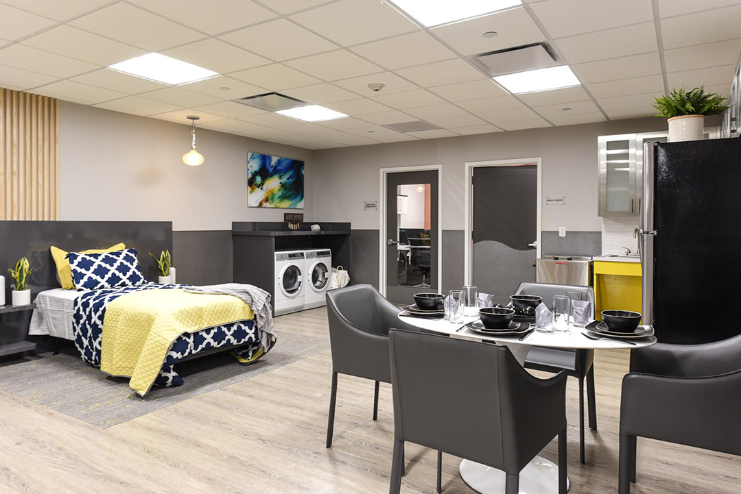 A modern room setup with a dining area and laundry.