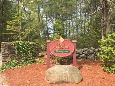 Signage for Alpine Nursing Home surrounded by greenery
