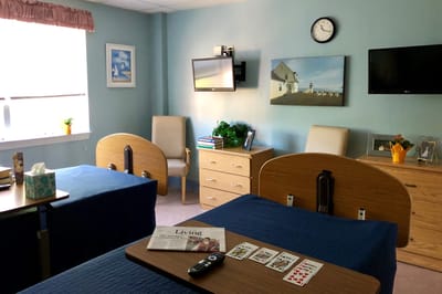 A well-furnished resident room with two beds and decor