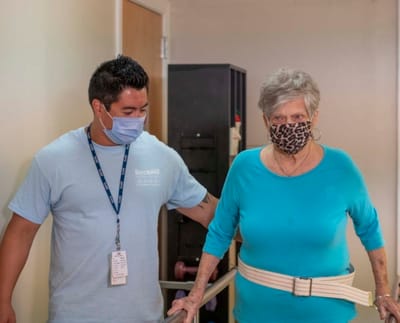 Staff assisting a resident in a hallway