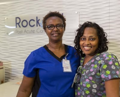 Two staff members smiling at a reception area