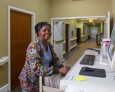 Staff member organizing files in a facility hallway
