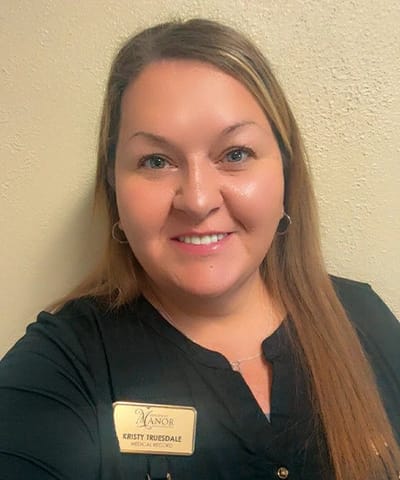 Staff member posing for a photo with name badge