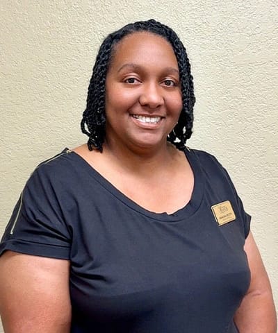 Staff member posing for a photo with a name badge