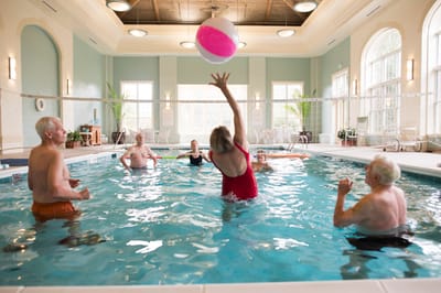 Residents enjoying a water volleyball game in the pool