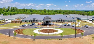 Aerial view of the assisted living facility with gardens and vehicles