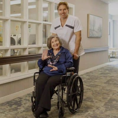 Staff member assisting a resident in a hallway