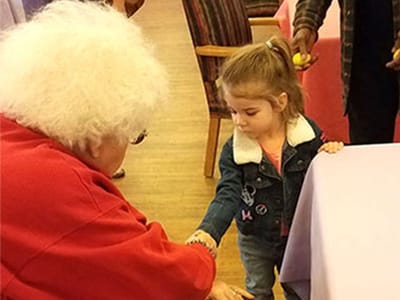 A resident interacting with a child at a social event