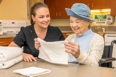 Caregiver assisting a senior resident with an activity