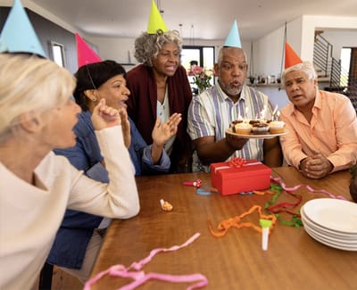 Residents celebrating at a birthday party with cake