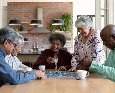 Residents enjoying a puzzle activity in a bright room
