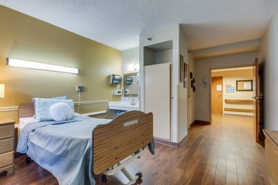 Bright, spacious resident room with a hospital bed