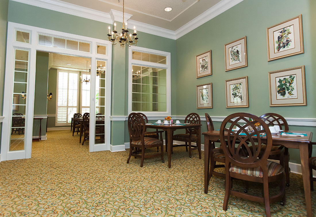 Dining room with tables and chairs in a green interior