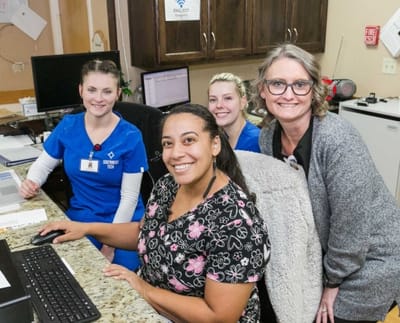 Staff members smiling at the reception desk