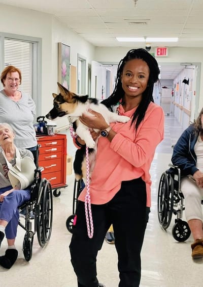 Staff member engaging with residents and a dog